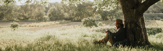 A man using lion's man for anxiety as he relaxes under a tree