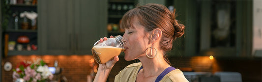 Older women holding two mushrooms as imitation breasts
